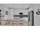 Bright kitchen with white cabinetry, stainless steel appliances, pendant lighting, and a spacious center island with seating at 302 Tammie Sue Ln, Deland, FL 32724