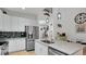 Bright kitchen with white cabinets, stainless steel appliances, and a large marble-topped island at 302 Tammie Sue Ln, Deland, FL 32724