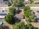 Aerial view showcasing a home with a brown roof nestled among green trees in a residential area at 31 Lake Dr, Debary, FL 32713
