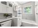 Bathroom with a tub, window, vanity with storage, and decorative mirror at 31 Lake Dr, Debary, FL 32713