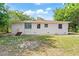 Exterior view of a single story home with a white exterior and greenery surrounding at 31 Lake Dr, Debary, FL 32713