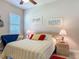 Comfortable bedroom with a queen bed, vibrant pillows, end tables, and beach-themed decor at 3148 Bailey Ann Dr, Ormond Beach, FL 32174