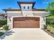A close up shot of the two-car garage featuring a decorative top and landscaped surroundings at 3148 Bailey Ann Dr, Ormond Beach, FL 32174