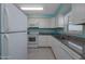 Kitchen with white cabinets, appliances and light blue walls at 3170 Ocean Shore Blvd # 5010, Ormond Beach, FL 32176