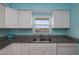 Galley kitchen with white cabinets and modern appliances at 3170 Ocean Shore Blvd # 5010, Ormond Beach, FL 32176