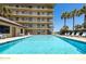 Community pool with chairs for relaxing by the pool at 3170 Ocean Shore Blvd # 5010, Ormond Beach, FL 32176