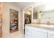 Bathroom with tiled floor, white vanity, and a view of a walk-in closet and bedroom at 32811 County Road 473, Leesburg, FL 34788