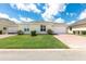 Single-story home featuring a two car garage, manicured shrubs, and a brick paved driveway at 3402 Torre Blvd, New Smyrna Beach, FL 32168