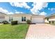 Single-story home featuring a two car garage, manicured shrubs, and a brick paved driveway at 3402 Torre Blvd, New Smyrna Beach, FL 32168