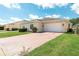 Single-story home featuring a two car garage, manicured shrubs, and a brick paved driveway at 3402 Torre Blvd, New Smyrna Beach, FL 32168