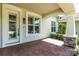 Welcoming front porch with brick flooring, columns, and a view of the home's entrance at 3402 Torre Blvd, New Smyrna Beach, FL 32168