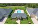 Aerial view of a community pool and clubhouse with a manicured lawn and mature trees at 3402 Torre Blvd, New Smyrna Beach, FL 32168