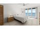 Comfortable bedroom with ceiling fan, tile flooring, natural light, and relaxing ocean view at 3425 S Atlantic Ave # 1602, Daytona Beach, FL 32118