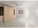 Bedroom with large wardrobe cabinets, tile floors, white walls, a mirror and standard ceiling fan at 3425 S Atlantic Ave # 1602, Daytona Beach, FL 32118
