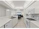 Open kitchen with white cabinets, tile floors, and stainless steel appliances that leads into a living area at 3425 S Atlantic Ave # 1602, Daytona Beach, FL 32118
