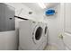 A well-lit laundry room featuring a front loading washer and dryer and metal storage racks at 3425 S Atlantic Ave # 1602, Daytona Beach, FL 32118