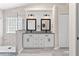 Modern bathroom features a double vanity, shiplap accent wall, and glass enclosed shower with decorative glass block window at 35 China Moon Dr, Ormond Beach, FL 32174
