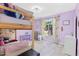 Bright bedroom with a bunk bed, colorful curtains, neutral gray flooring and soft purple walls at 35 China Moon Dr, Ormond Beach, FL 32174