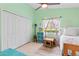 A cheerful bedroom features green walls, a ceiling fan, and large closet and window at 35 China Moon Dr, Ormond Beach, FL 32174