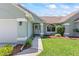 Inviting front exterior with lush landscaping, and a covered entrance to the home at 35 China Moon Dr, Ormond Beach, FL 32174