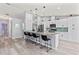 Open concept kitchen boasts modern white cabinetry, a long center island with barstools, and stainless steel appliances at 35 China Moon Dr, Ormond Beach, FL 32174