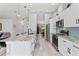 Modern kitchen features white cabinets, stainless steel appliances, a large kitchen island, and light blue subway tile backsplash at 35 China Moon Dr, Ormond Beach, FL 32174