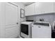 Well-equipped laundry room with washer, dryer, and storage cabinets at 35 China Moon Dr, Ormond Beach, FL 32174