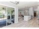Open concept living area leading into the kitchen with a view to a sunroom and an adjacent living room at 35 China Moon Dr, Ormond Beach, FL 32174
