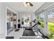 Bright sunroom features workout equipment, tile flooring, and a view of the backyard at 35 China Moon Dr, Ormond Beach, FL 32174