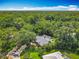 Aerial view of a secluded home with a screened pool, surrounded by lush, mature trees, ensuring privacy at 4073 N Chinook Ln, Ormond Beach, FL 32174