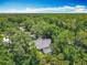 Aerial shot features a charming home with a screened pool, surrounded by lush landscaping, and mature trees at 4073 N Chinook Ln, Ormond Beach, FL 32174