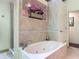 Relaxing soaking tub in a tiled bathroom with decorative accents and a separate shower at 4073 N Chinook Ln, Ormond Beach, FL 32174