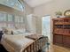 Cozy bedroom featuring a large arched window, shutter blinds and access to a private bathroom at 4073 N Chinook Ln, Ormond Beach, FL 32174
