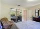 Comfortable bedroom featuring mirrored closet doors, a cozy chair, and natural light from a window at 4073 N Chinook Ln, Ormond Beach, FL 32174
