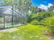 A screened-in pool area, surrounded by lush green landscaping, offers a peaceful and private outdoor retreat at 4073 N Chinook Ln, Ormond Beach, FL 32174