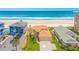 Stunning aerial shot showcases a beautiful beach house with vibrant landscaping and direct beach access at 4427 S Atlantic Ave, Port Orange, FL 32127