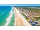 Aerial view of beautiful coastal neighborhood with beachfront properties and lush greenery at 4427 S Atlantic Ave, Port Orange, FL 32127