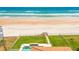 Aerial view of backyard featuring a pool, lush lawn, and steps leading to the beach at 4427 S Atlantic Ave, Port Orange, FL 32127