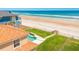 An aerial shot of backyard with pool, green lawn, and private beach access at 4427 S Atlantic Ave, Port Orange, FL 32127