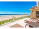 Balcony with lounge chairs and ocean view with white railings and lush green grass at 4427 S Atlantic Ave, Port Orange, FL 32127