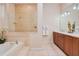 A stylish bathroom featuring a soaking tub, dual vanities, and a glass-enclosed shower at 4427 S Atlantic Ave, Port Orange, FL 32127