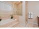 A bright bathroom features a soaking tub with tile surround and glass shower enclosure at 4427 S Atlantic Ave, Port Orange, FL 32127