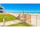 Walkway to a sandy beach featuring a shower and stairs, enhancing coastal living experience at 4427 S Atlantic Ave, Port Orange, FL 32127