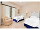 Comfortable guest bedroom features two twin beds and a cozy armchair for relaxation at 4427 S Atlantic Ave, Port Orange, FL 32127
