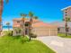 Beautiful two-story home with palm trees, a terracotta roof, and a paved driveway at 4427 S Atlantic Ave, Port Orange, FL 32127