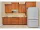 Kitchen features wood cabinetry, a white refrigerator, and tile flooring at 4427 S Atlantic Ave, Port Orange, FL 32127