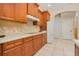 Kitchen area with wooden cabinets, white appliances, and tiled flooring at 4427 S Atlantic Ave, Port Orange, FL 32127