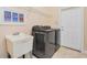 This laundry room has a washing machine, dryer, utility sink and exterior door at 4427 S Atlantic Ave, Port Orange, FL 32127