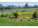 Landscaped backyard with pond, lush grass, and colorful flower bed, creating a tranquil outdoor space at 460 Sarah Nicole Way, New Smyrna Beach, FL 32168