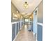 Inviting hallway with tile floors, wainscoting, and decorative lighting at 460 Sarah Nicole Way, New Smyrna Beach, FL 32168